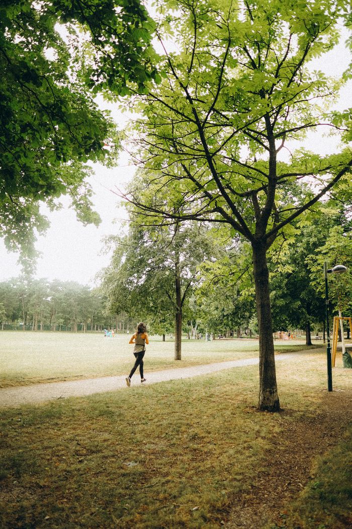 Crafting Captivating Headlines: Your awesome post title goes here Woman jogging on a tree-lined pathway in a green park during daytime for fitness.